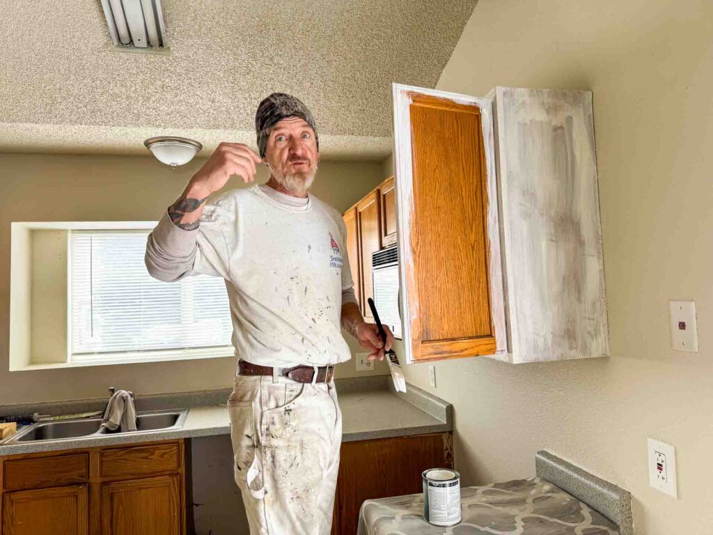 a man painting a cabinet