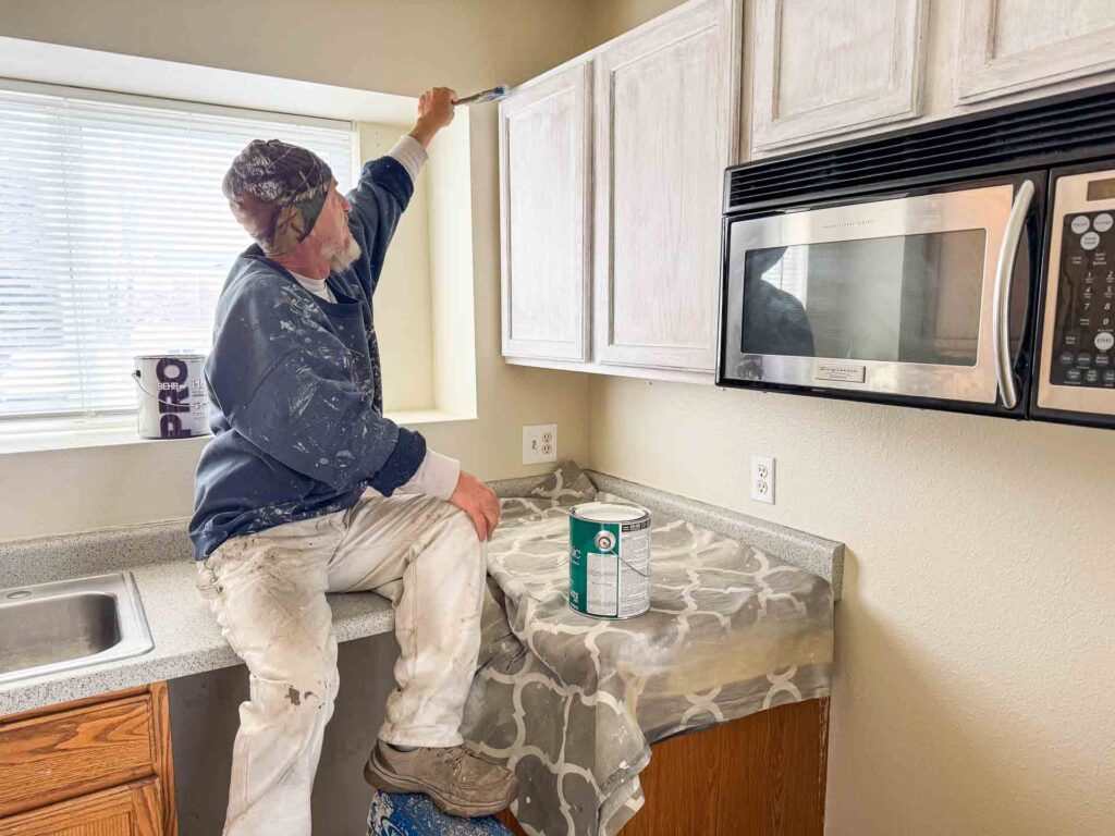 a man painting a kitchen