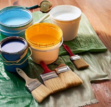 paint cans of paint and brushes on the floor